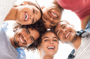 Upwards shot of a group of friends huddled together and smiling