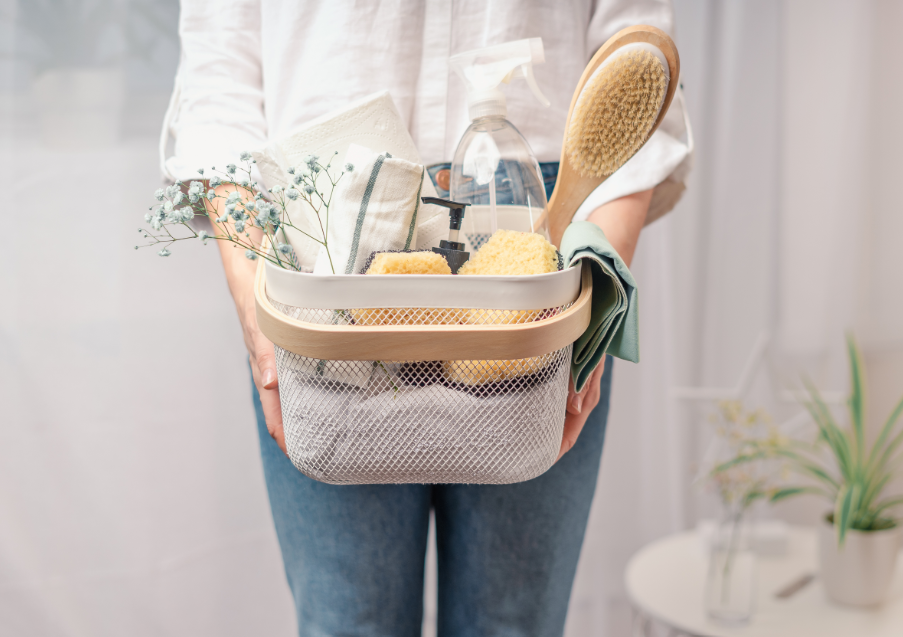 Woman holding basket of cleaning supplies
