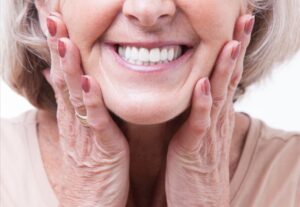 Older woman smiling with dentures.