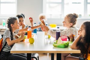 Kids eating at lunch table at school.